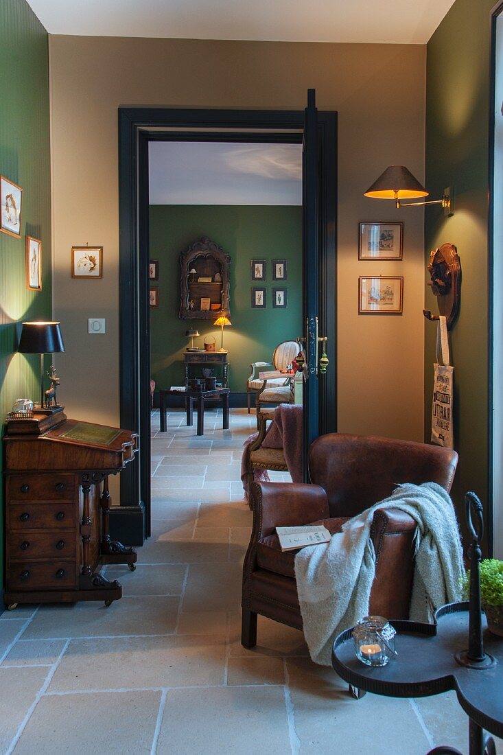 Leather armchair and writing desk in room with walls in shades of green and beige