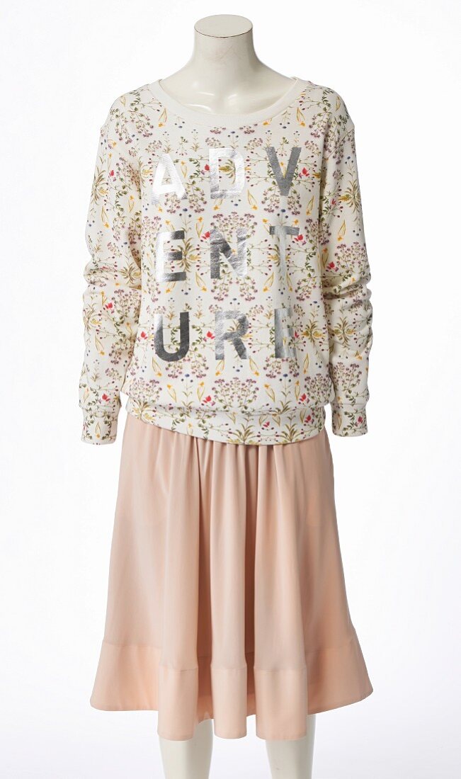 A patterned sweater and a pastel-coloured midi skirt on a headless mannequin