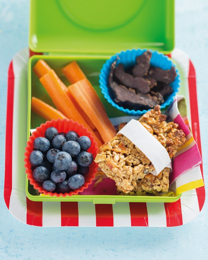 Muesli bars, blueberries and carrots in a lunch box