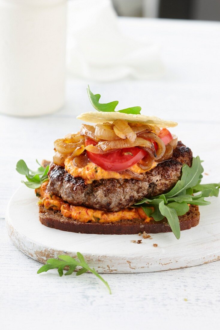 Turkey burger with caramelised onions and hummus on rye bread