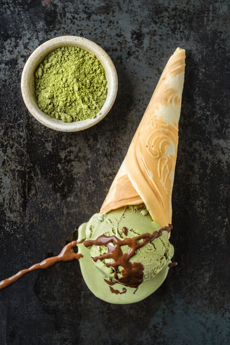 Green tea ice cream with chocolate sauce in a homemade ice cream cone