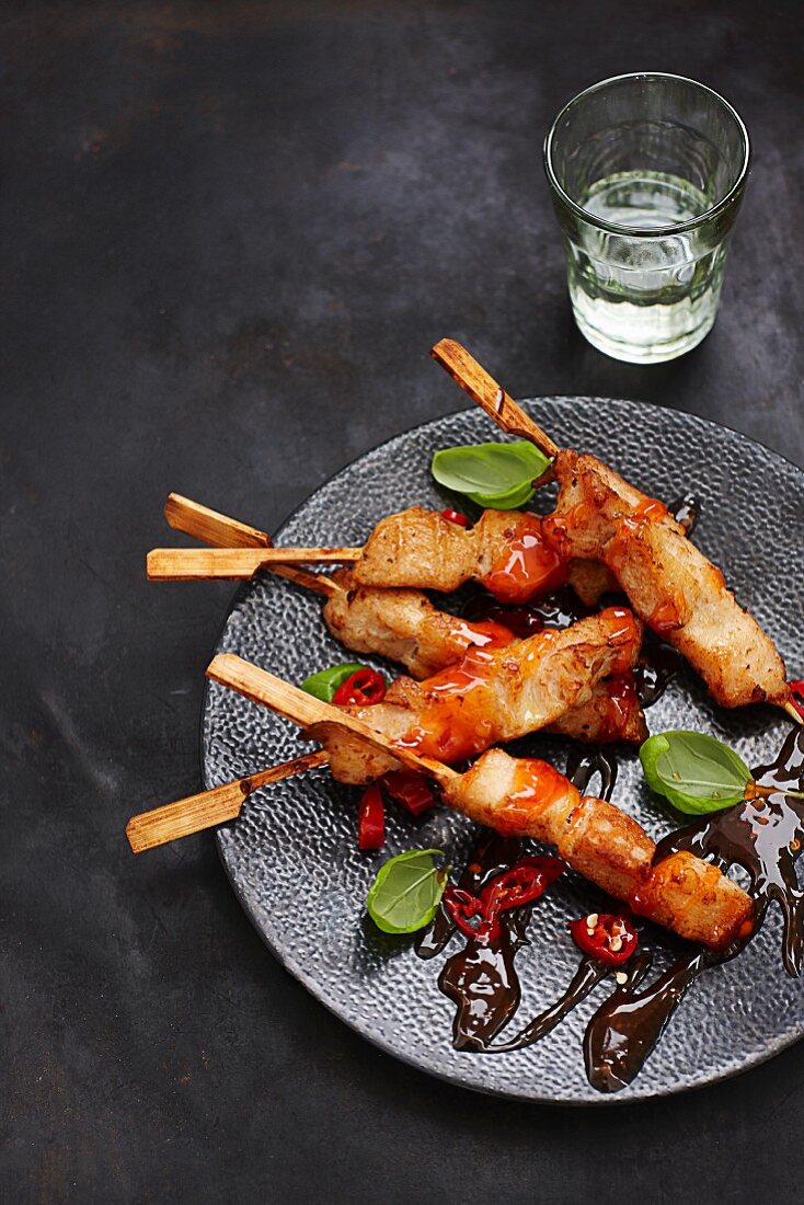 Chicken skewers with sweet-and-sour sauce and chili rings