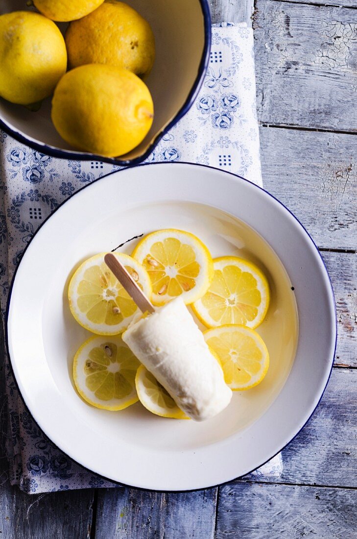 A lemon ice lolly on lemon slices