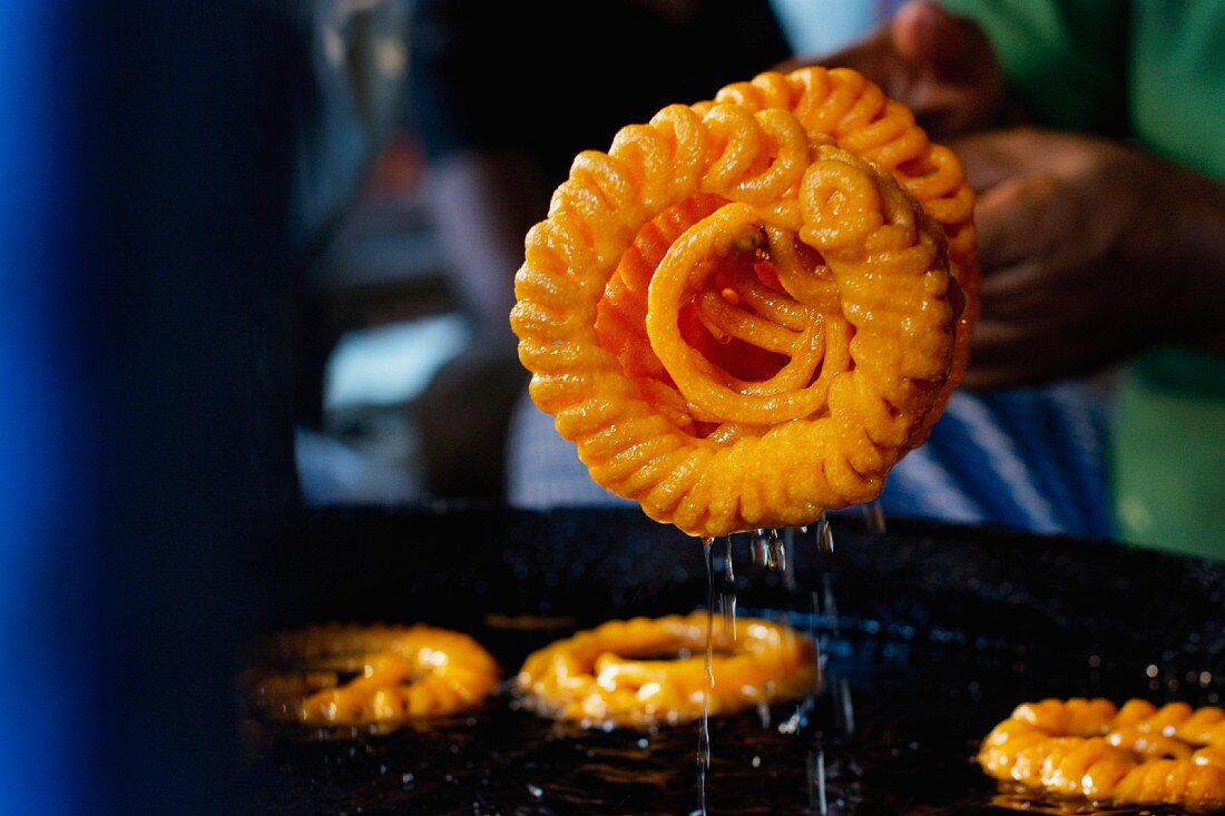 Hot jalebis being removed from oil (sweet piped pastries, India)