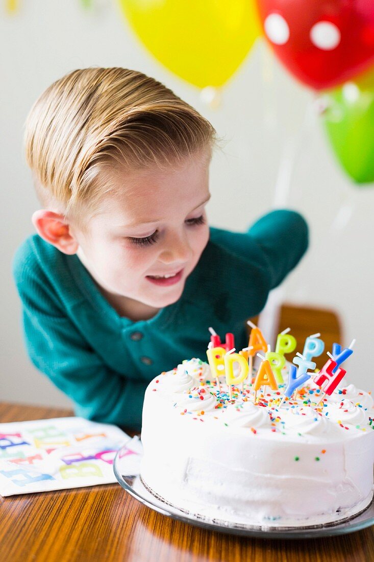 A little boy looking at a birthday cake