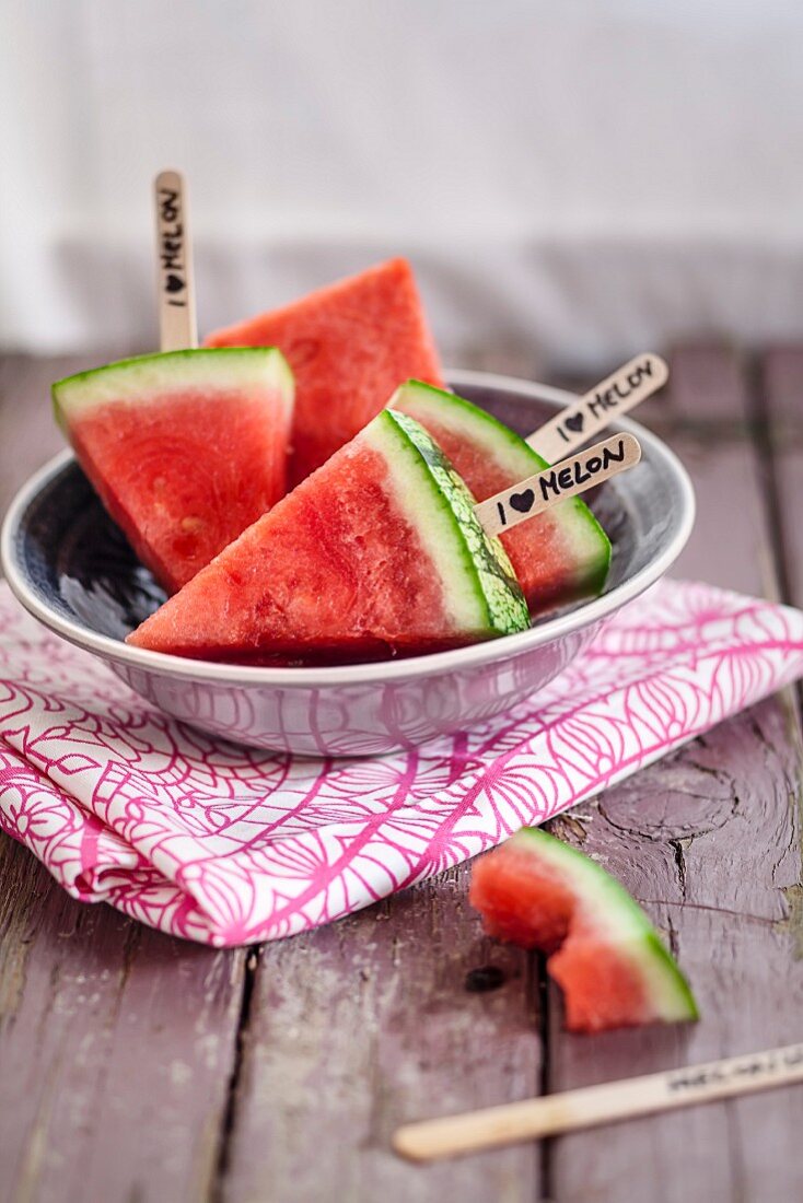 Watermelon slices on sticks in a bowl