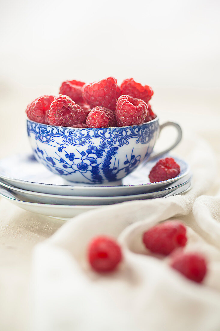Raspberries in and around a teacup