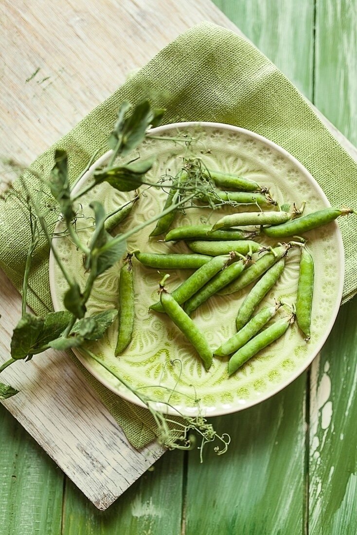 Peapods on a green plate