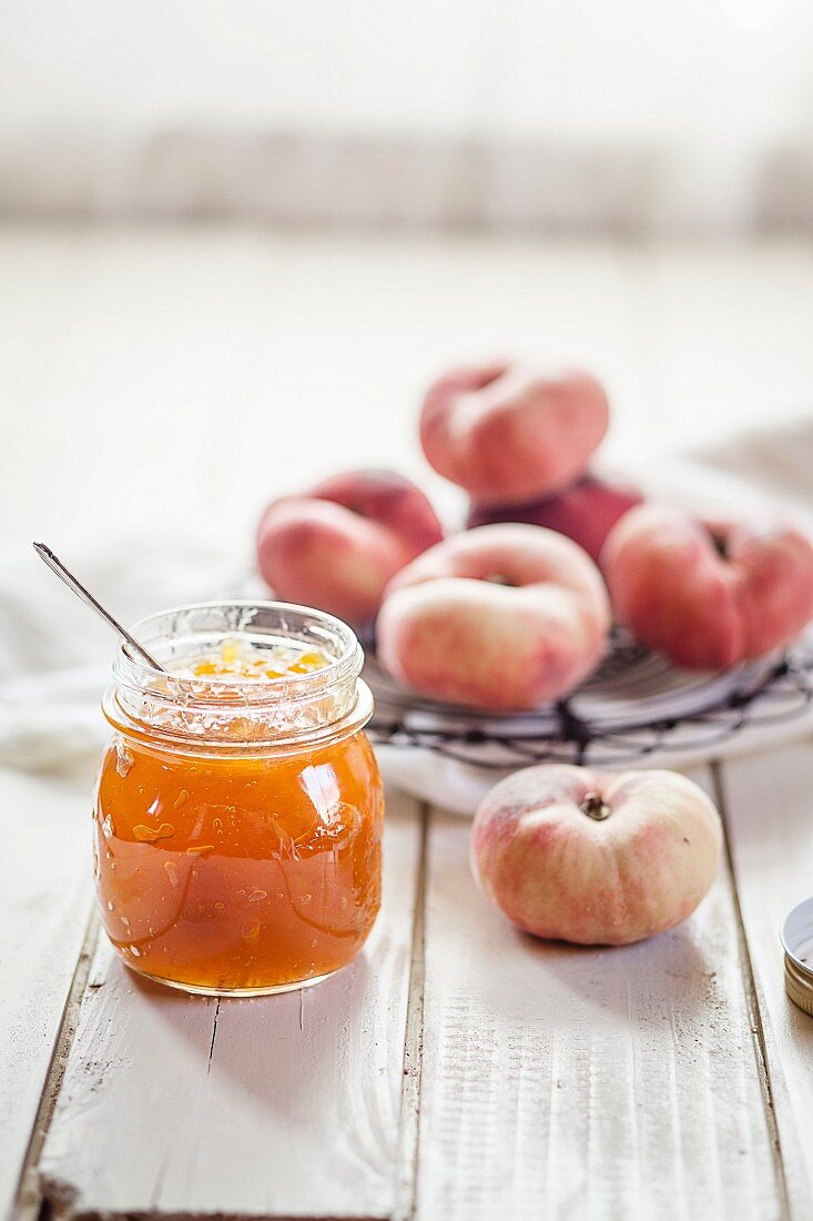 A jar of peach jam and vineyard peaches