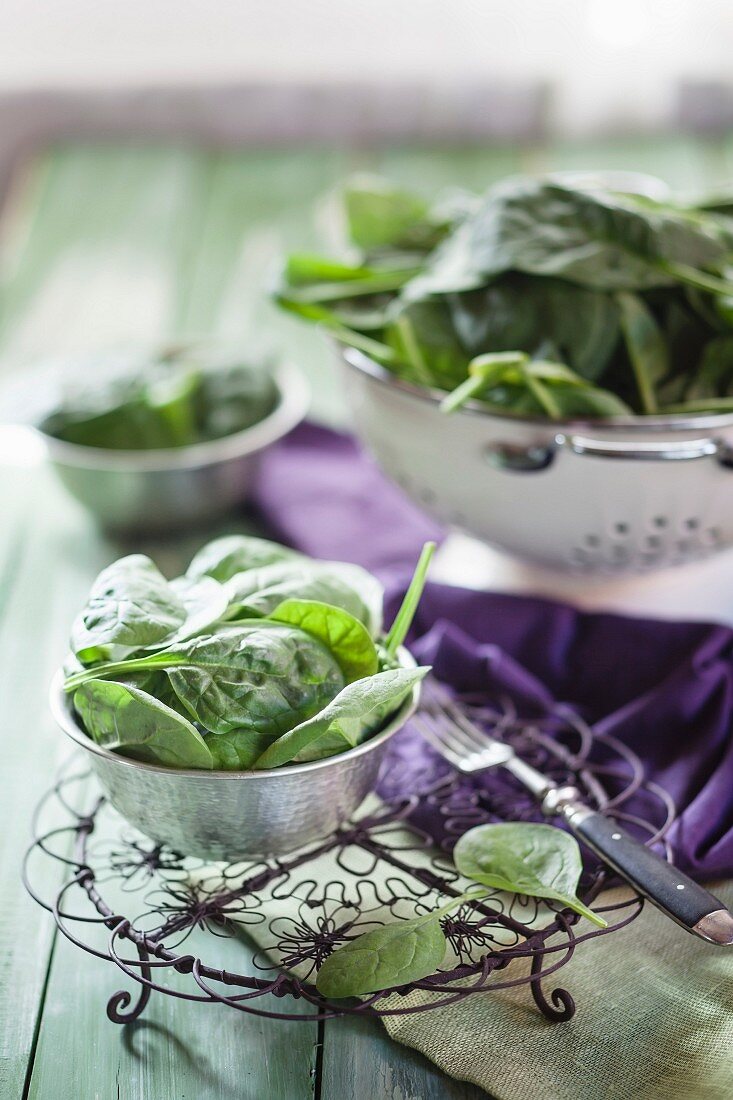 Fresh spinach in a bowl and in a colander