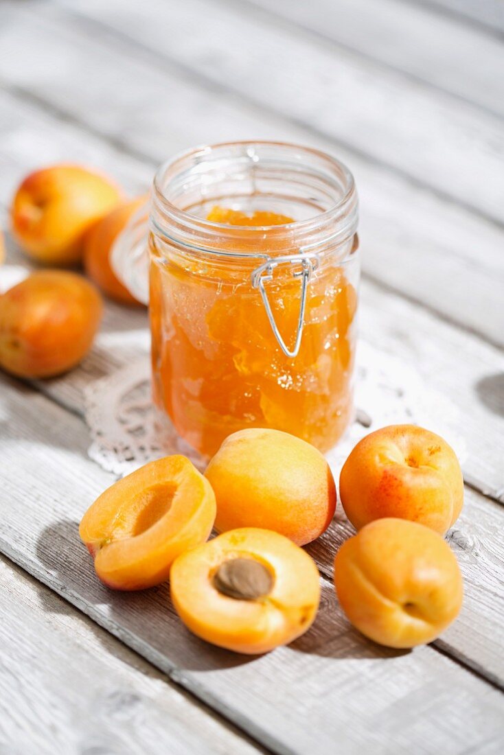 A jar of apricot jam and fresh apricots