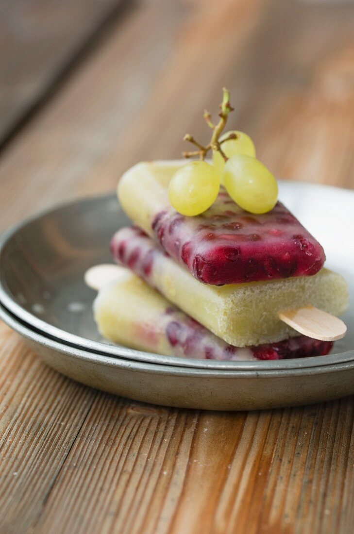 Homemade grape and pomegranate ice lollies with green grapes