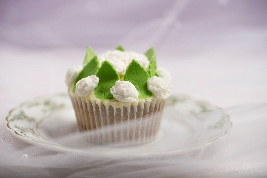 A cupcake decorated with rose petal fondant