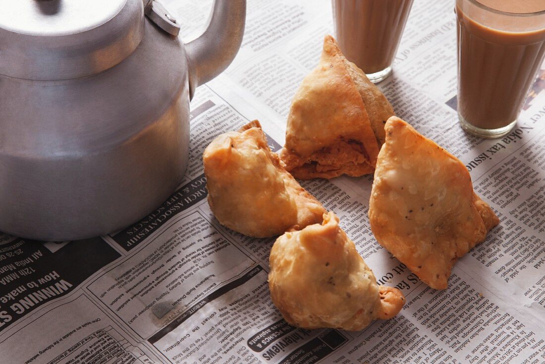 Fresh samosas and tea on newspaper