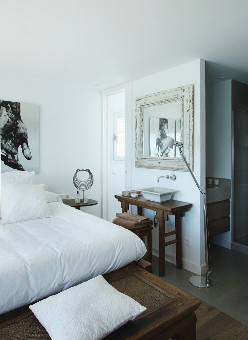 Rustic wooden bench at foot of double bed in bedroom