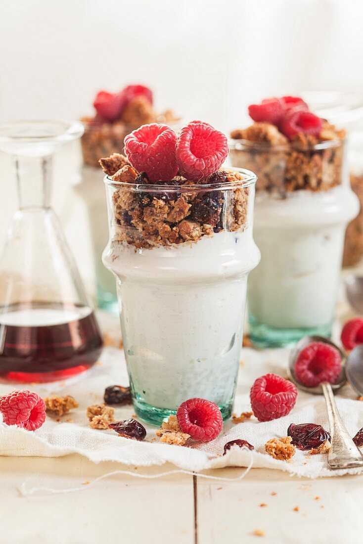 Homemade gluten-free nut muesli with Greek yoghurt, raspberries and maple syrup