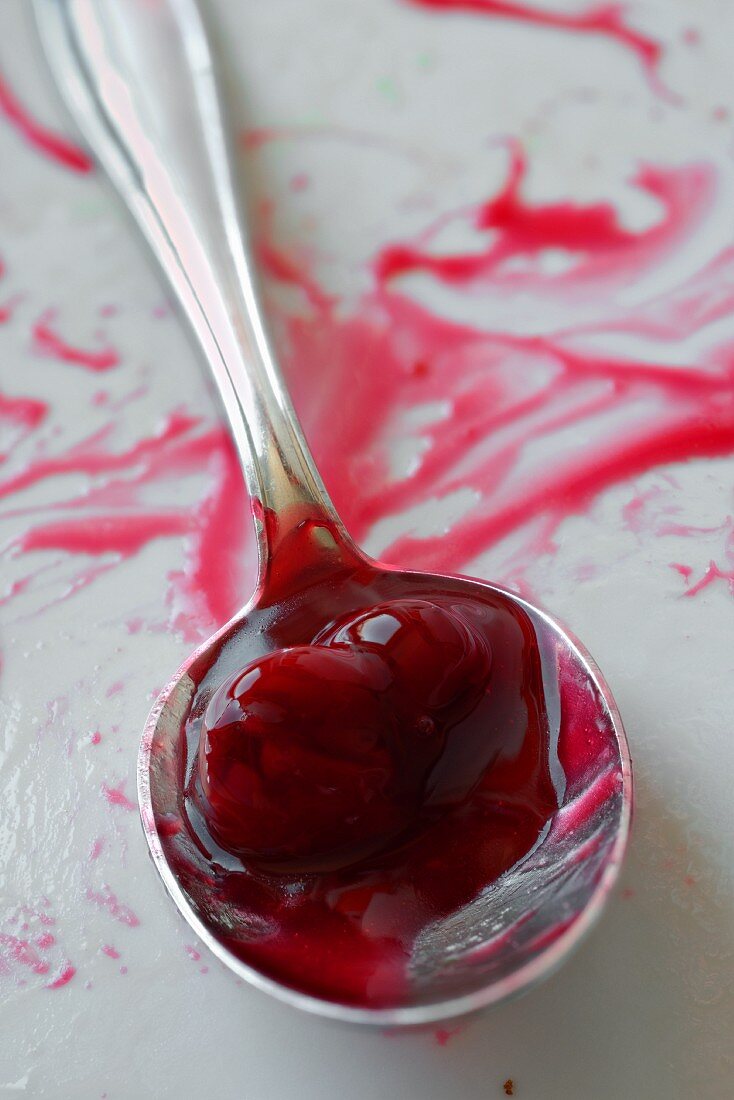 The remains of cherry compote on a silver spoon