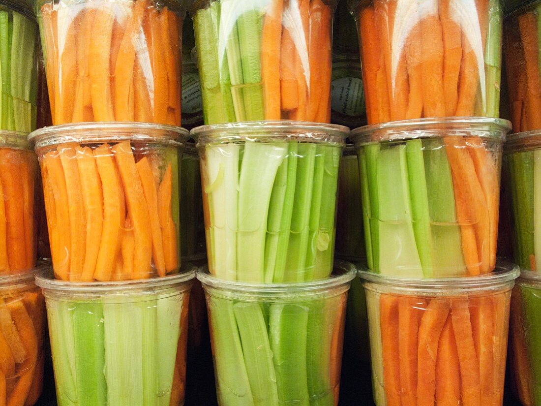 Julienned vegetables in plastic cups at a market