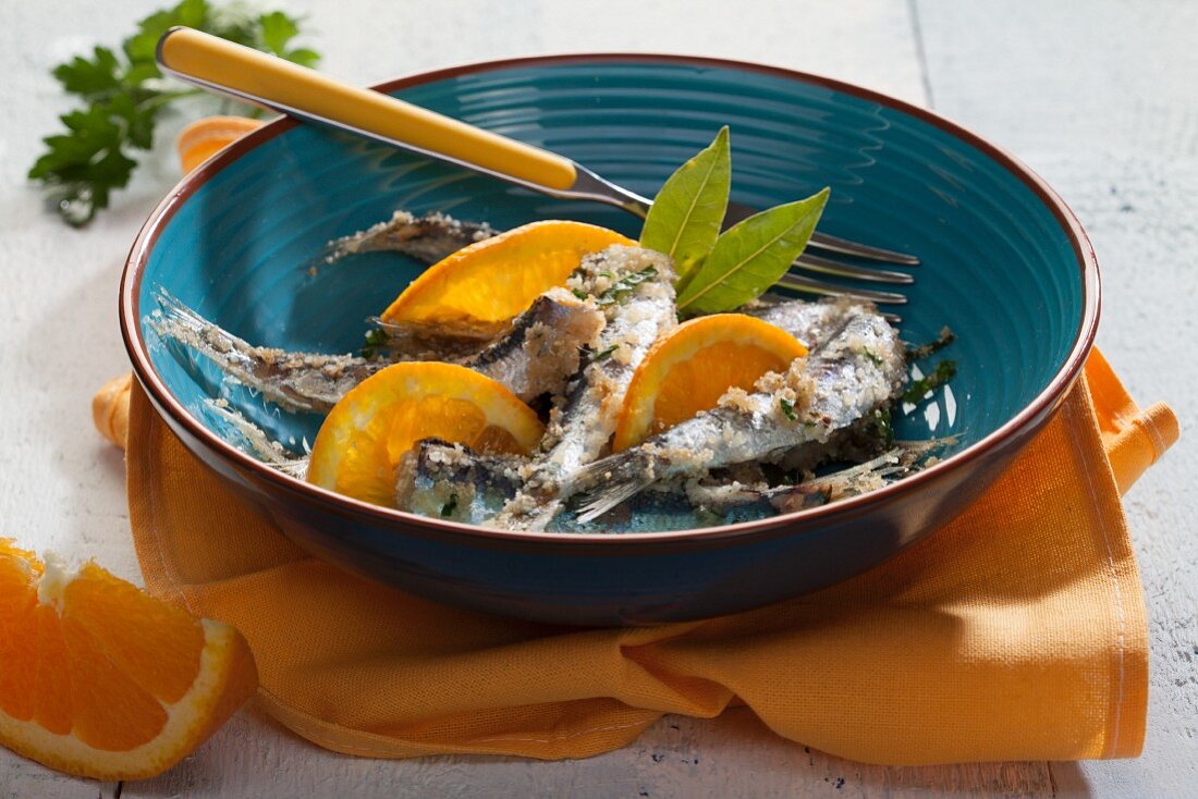 Breaded sardines with orange and bay leaves