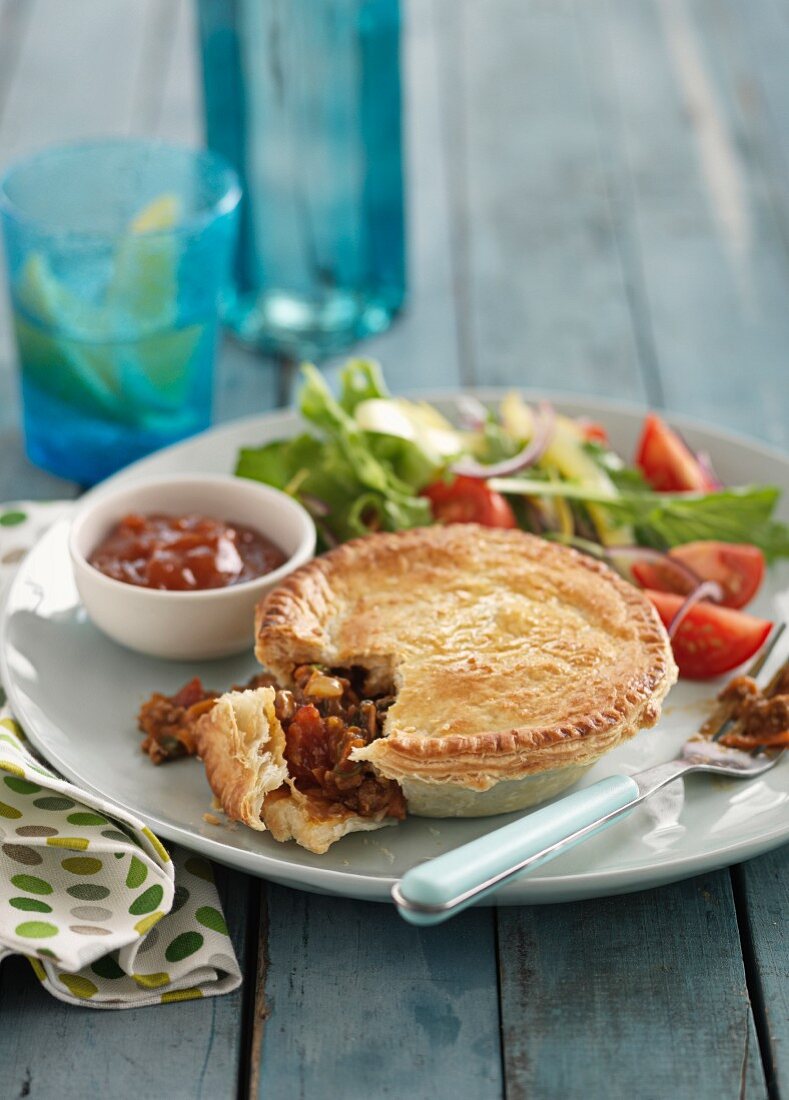 Hearty lamb pie with salad and ketchup