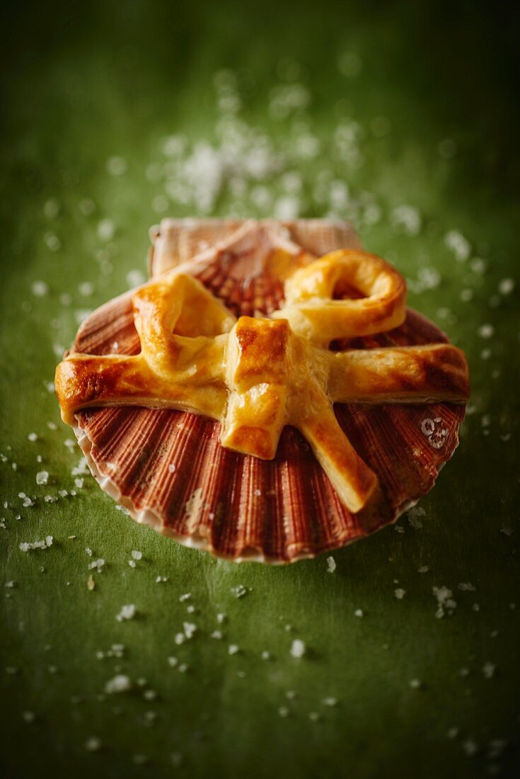 A puff pastry bow on top of a scallop