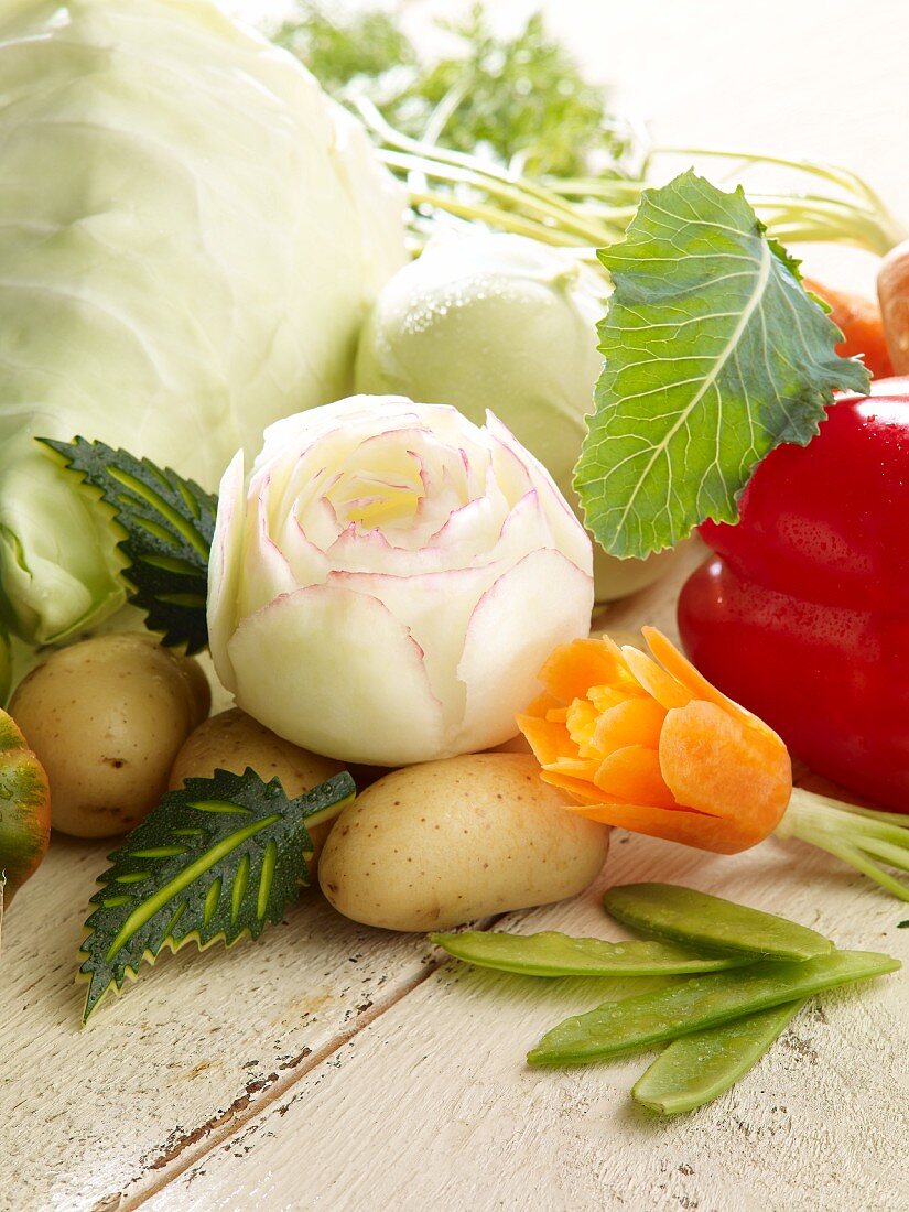 A carved kohlrabi rose, a carrot flower and various types of vegetables