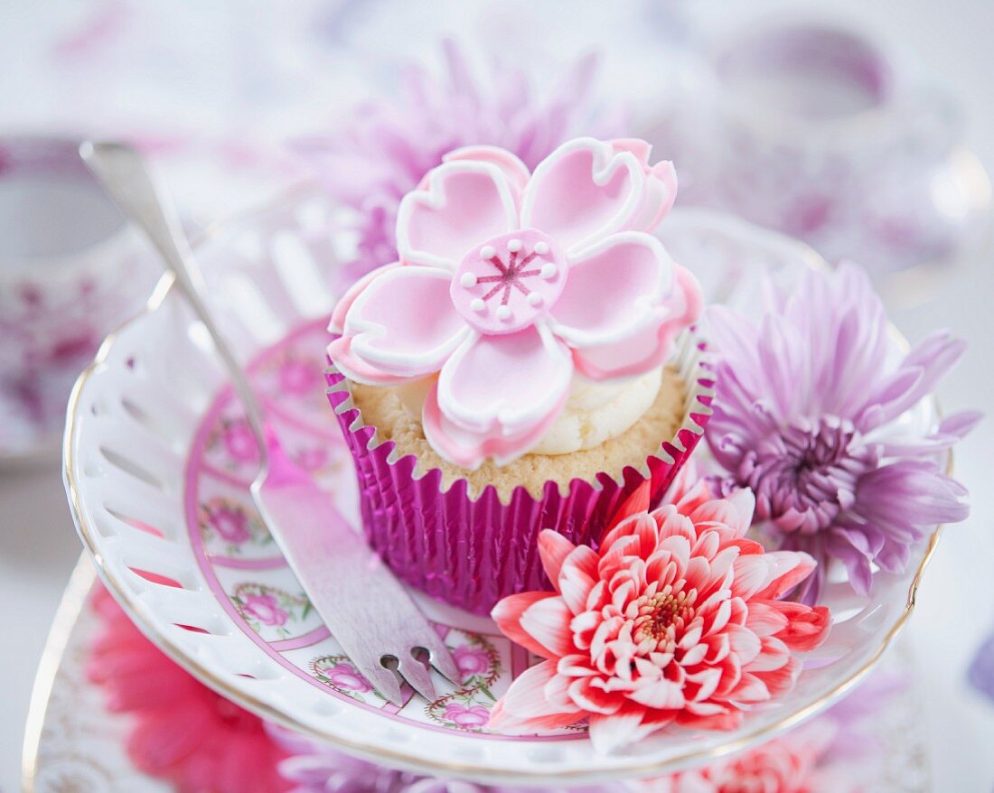 A cupcake decorated with a white fondant flower