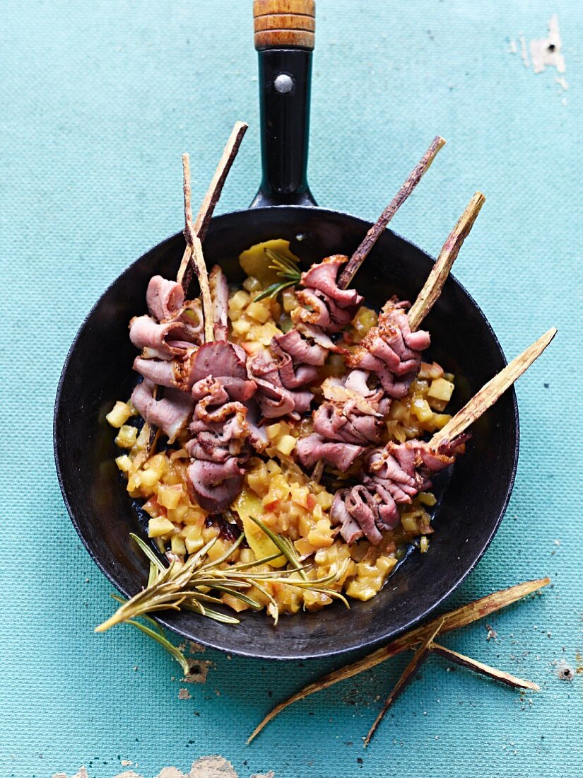 Duck satay skewers in a wok