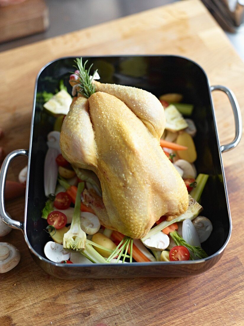 Corn-fed chicken on vegetables in a roasting tin