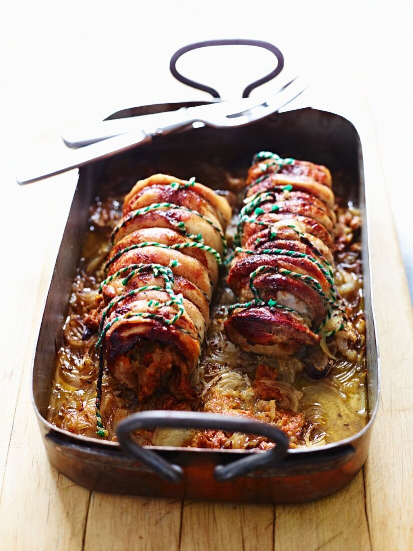 Suckling pig roulade in a roasting tin