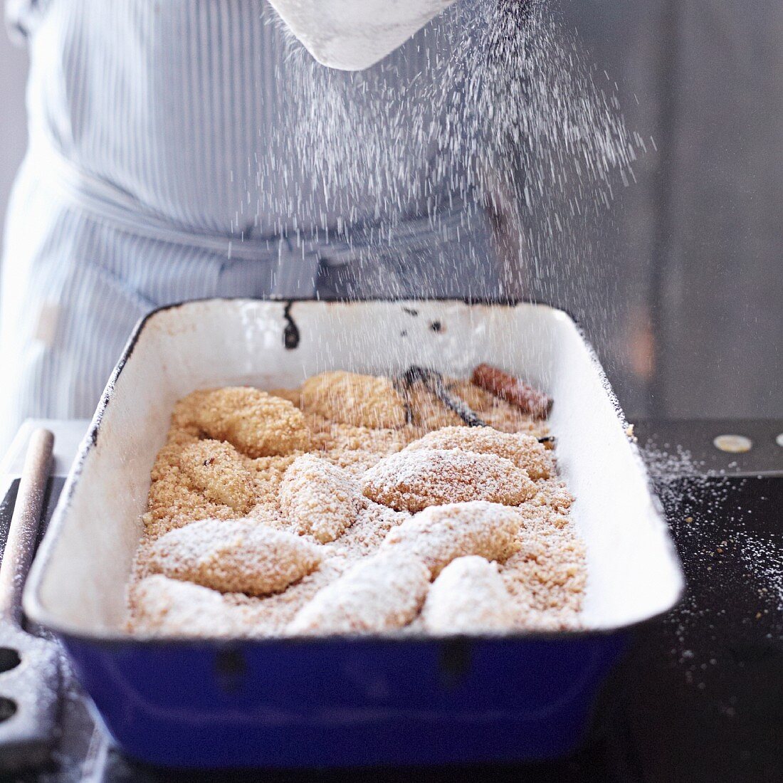 Topfenknödel in Butterbröseln mit Puderzucker bestreuen