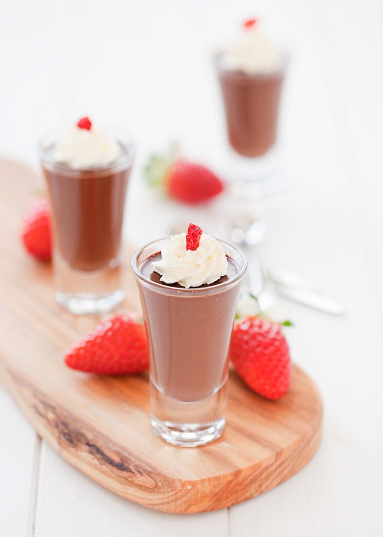 Three small chocolate pots with cream and strawberries