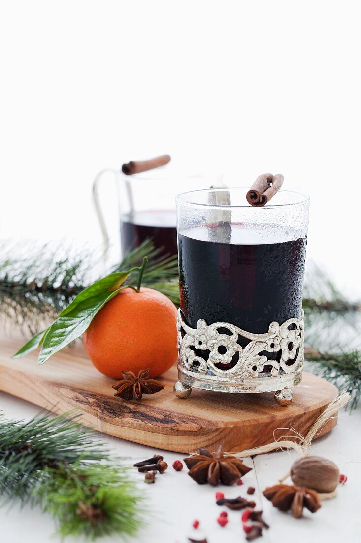 Two glasses of mulled wine with spices and sprigs of fir