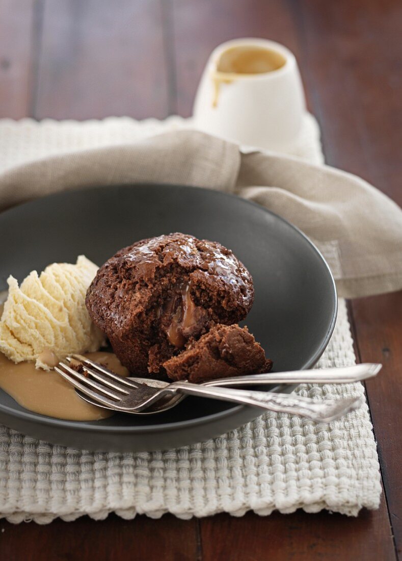 A chocolate muffin with caramel sauce and vanilla ice cream