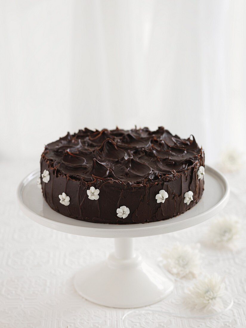 Schokoladenkuchen mit Zuckerblumen auf Kuchenständer