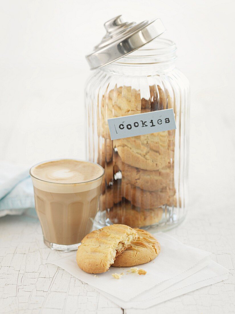 Cookies in a storage jar and caffe latte