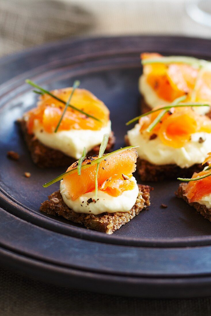 Rye bread crackers topped with smoked salmon and cream cheese