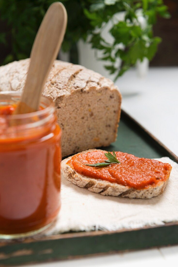 Ajvar (Paprikamus) im Glas und auf Brot