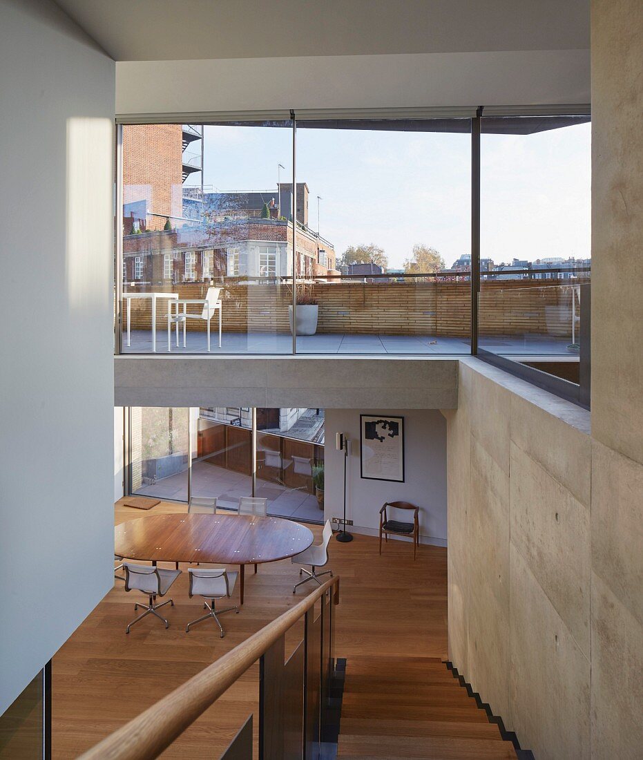 View through glass wall of terrace above open-plan interior