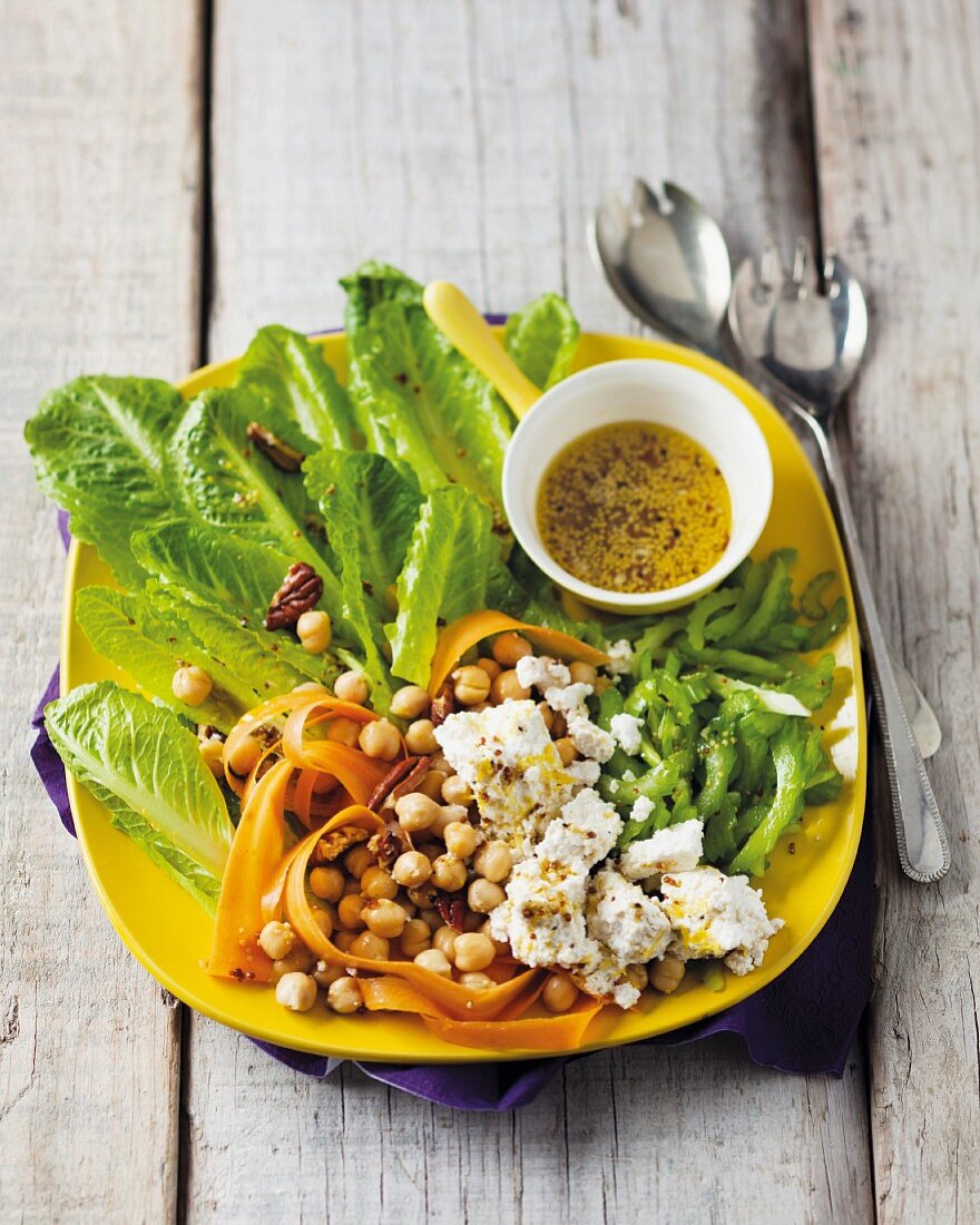 A summer salad platter with cos lettuce, chick peas, carrots, celery, feta cheese and a mustard vinaigrette