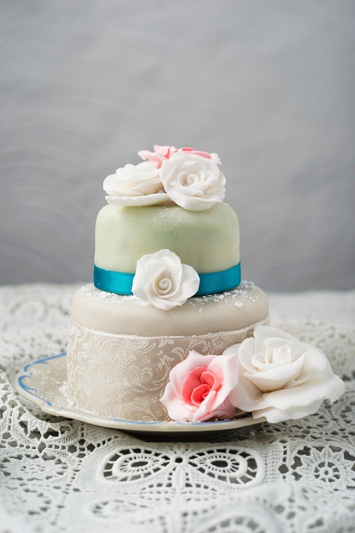 A cake decorated with fondant icing and sugar roses