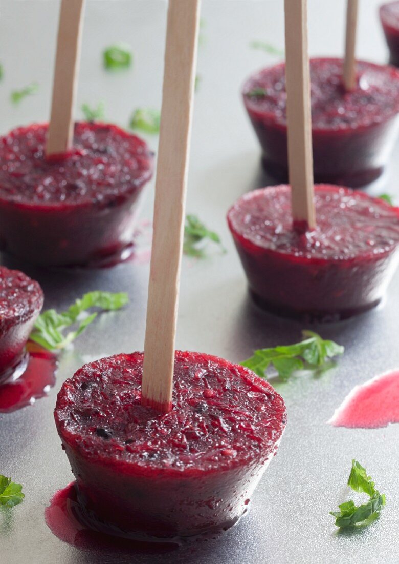 Homemade grapefruit and blackberry ice lollies on a silver tray