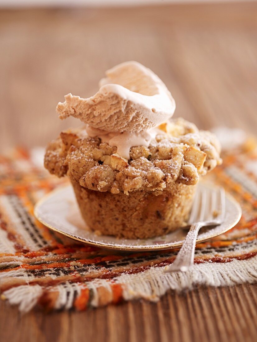 An apple crumble cupcake top with a scoop of ice cream
