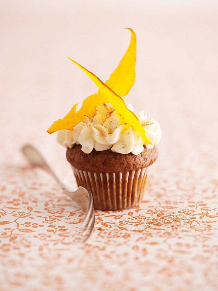 A Pumpkin Spice Cupcake with a Pumpkin Candy on a Green Plate