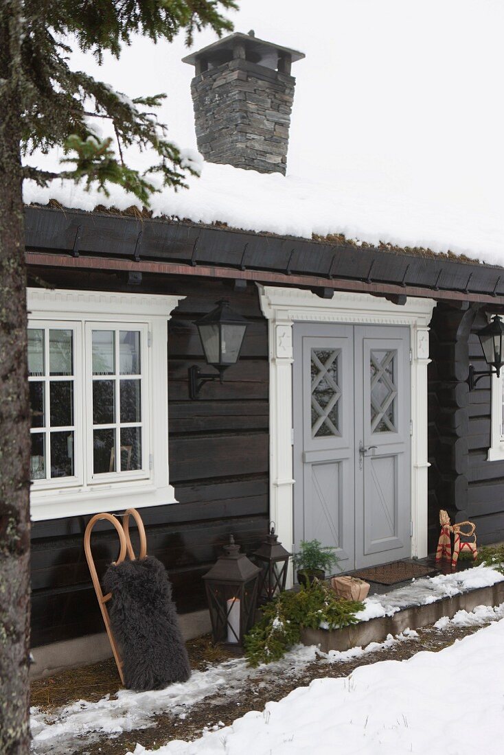 Schneebedecktes Holzhaus im Blockhausstil