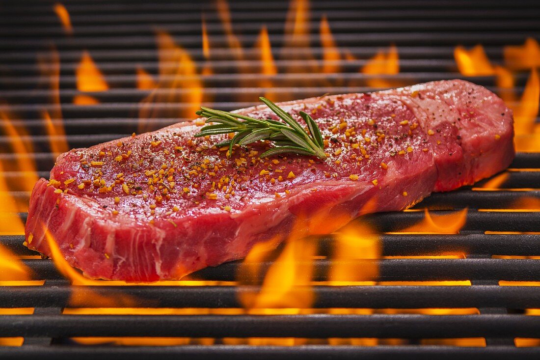 Tri Tip Steak mit Rosmarin und Gewürzen auf dem flammenden Grill