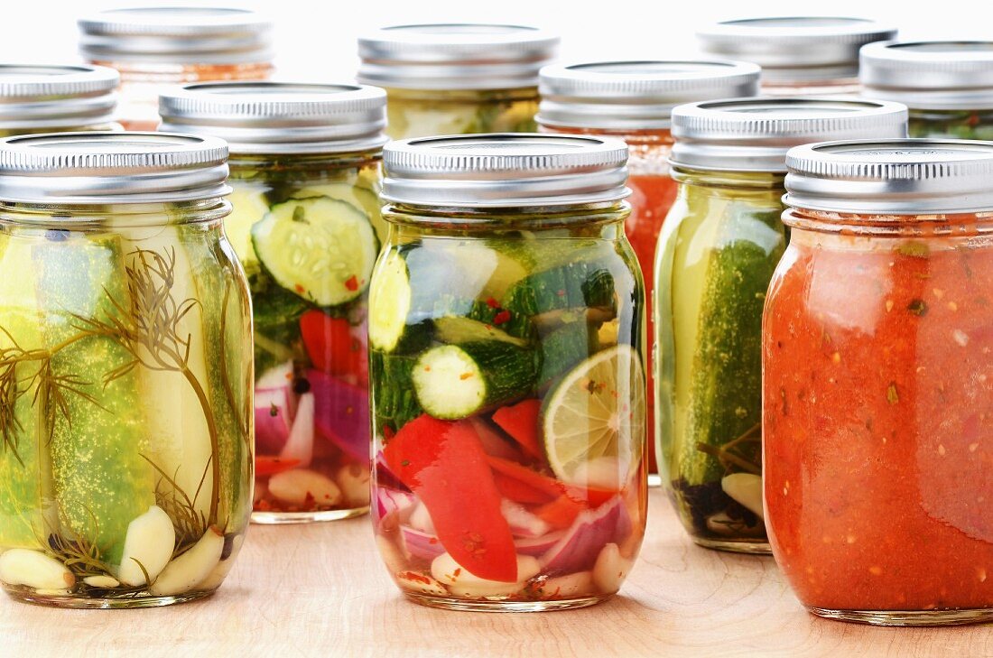 Mediterrane Gemüsekonserven in Gläsern: Gurken, Zucchini, Paprika, Zwiebeln, Zitrone und Tomatensauce