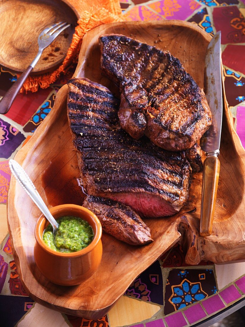 Grilled steak with mint sauce on a laid table (South America)
