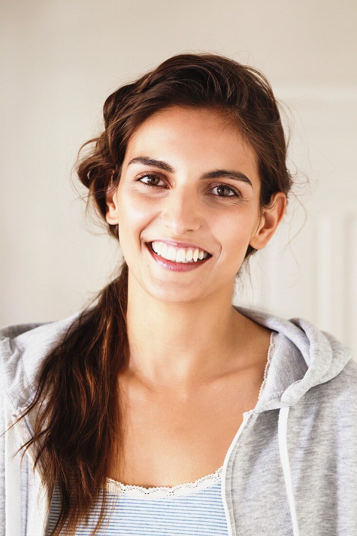 Young, brunette woman wearing hooded sweater