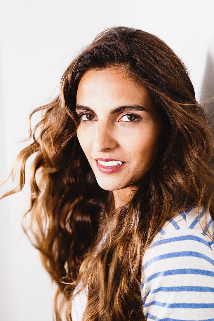 Young, brunette woman wearing white and blue striped top